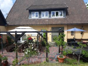 Casa con patio al aire libre con sombrillas en Gästehaus HarzGlück, en Braunlage