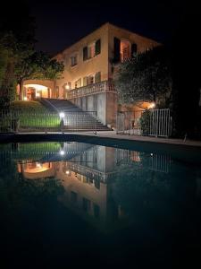 a building and a swimming pool at night at Le Cheval Blanc in Vauvert