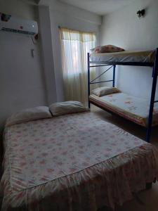 a bedroom with two bunk beds and a window at Alojamientos Nazareth in Catia La Mar