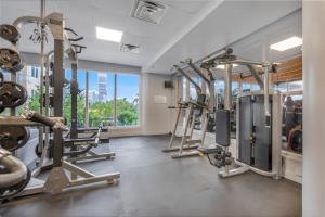 een fitnessruimte met diverse loopbanden en een groot raam bij Breezy Beach and Perfect Sunset in Miami