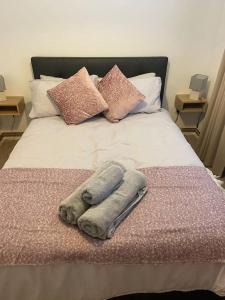 een bed met twee handdoeken en kussens erop bij One bedroom ground floor flat central Chichester in Chichester
