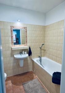 a bathroom with a tub and a sink and a mirror at Perła Mazur przy Promenadzie Mikołajki in Mikołajki