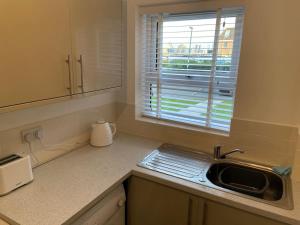 a kitchen counter with a sink and a window at One bedroom ground floor flat central Chichester in Chichester +16 photos