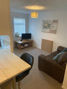 a living room with a table and a couch at One bedroom ground floor flat central Chichester in Chichester