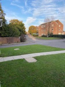 a grassy yard with a sidewalk and a brick building at One bedroom ground floor flat central Chichester in Chichester