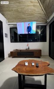 un soggiorno con tavolino e TV a schermo piatto di Résidence Kali a Guediawaye