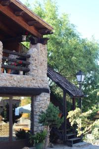 un edificio de piedra con una luz de la calle delante de él en Alojamientos Turisticos La Utrera, en Las Majadas