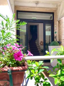une porte menant à un bâtiment avec des plantes et des fleurs dans l'établissement Hotel Arcadia, à Macerata