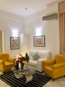 sala de estar con sofá blanco y 2 sillas amarillas en Hotel Arcadia, en Macerata
