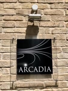 una señal en el lateral de un edificio de ladrillo en Hotel Arcadia, en Macerata
