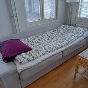 uma cama grande num quarto com duas janelas em two-room apartment midle in Kotka with sauna em Kotka