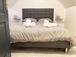 a bedroom with a large bed with two white pillows at Maison des Ollivier - Maison Campagne Fécampoise in Toussaint
