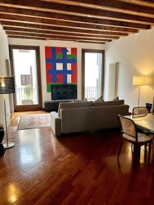 a living room with a couch and a tv at Il Portico. Charm apartment, Vicenza downtown. in Vicenza