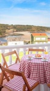 une table avec une assiette de nourriture sur un balcon dans l'établissement AG Casa Fuentes Canduas 1, à A Telleira