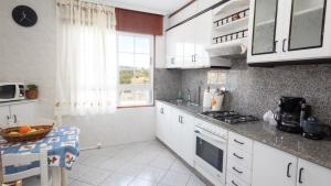 une cuisine avec des placards blancs et un comptoir dans l'établissement AG Casa Fuentes Canduas 1, à A Telleira
