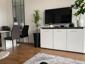 a living room with a television on a white cabinet at Mistral Residence 408 in Balatonföldvár