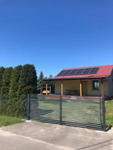 a house with solar panels on a fence at Domek wypoczynkowy Leszek in Żarnowska