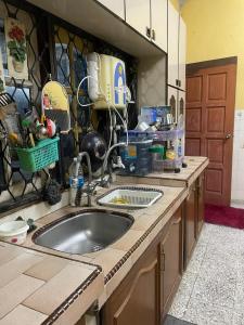 Kampong Guar ChempedakALIFUMAI HOMESTAY GUAR CHEMPEDAK YAN KEDAH的带水槽和台面的厨房