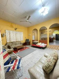 Kampong Guar ChempedakALIFUMAI HOMESTAY GUAR CHEMPEDAK YAN KEDAH的客厅里有一张沙发和一张桌子。 更多34张照片