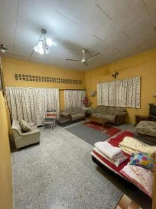 Kampong Guar ChempedakALIFUMAI HOMESTAY GUAR CHEMPEDAK YAN KEDAH的带床和沙发的客厅