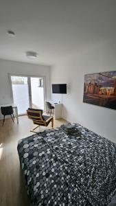 a bedroom with a bed and a chair and a television at Ferienwohnung Hesse Ilsede in Ilsede