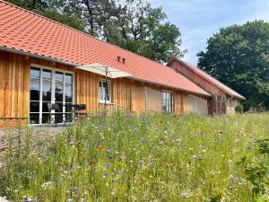 una casa con un campo di fiori davanti di Hotel TraumzeitHof a Eschede