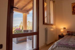 1 dormitorio con vistas a una cama y una ventana en Beth la Casa della Luna en Annunziata