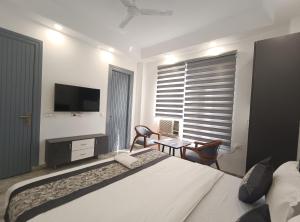 新德里的住宿－HOTEL GREEN VEGAS，一间卧室配有一张床、一张书桌和一台电视