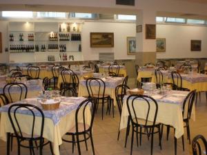 リミニにあるHotel Concordia Palaceのダイニングルーム(テーブル、椅子、白いテーブルクロス付)