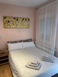 een slaapkamer met een bed met twee handdoeken erop bij Ático terraza con vistas únicas, centro histórico in Salamanca