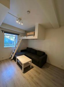 a living room with a couch and a stair case at Welcome to Heddalsvegen 43, Notodden's most welcoming dormitory! in Notodden