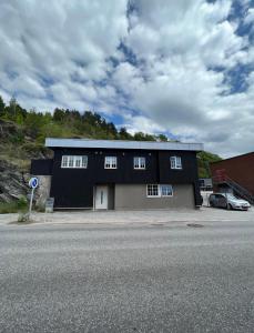 ein schwarzes und graues Gebäude an der Seite einer Straße in der Unterkunft Welcome to Heddalsvegen 43, Notodden's most welcoming dormitory! in Notodden