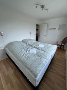 een groot bed in een kamer met een stoel bij Jyske ås in Dybvad