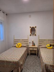 a bedroom with two beds with smiley pillows on them at Orisol in Vinaròs