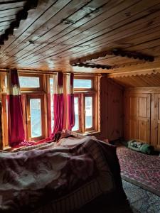sypialnia z łóżkiem w pokoju z oknami w obiekcie Kahn trekking guesthouse w mieście Nikri Dhokri