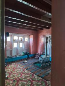 pusty pokój z kominkiem w pokoju z czerwonymi ścianami w obiekcie Kahn trekking guesthouse w mieście Nikri Dhokri