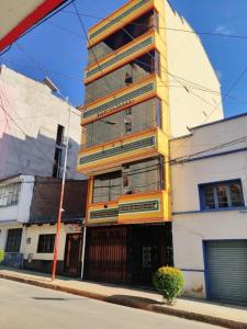 un edificio alto al lado de una calle en COMODORO DEPARTAMENTOS en Oruro