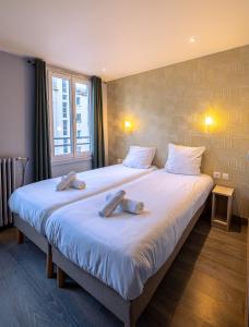 a bedroom with a large bed with towels on it at Hotel Aix Europe in Paris