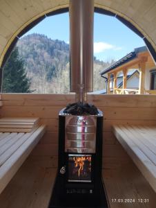 an outdoor stove in a room with two windows at Bystre Chaty in Bystre
