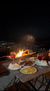 a table with plates of food and glasses of wine at Superview Lodge Sarangkot in Pokhara