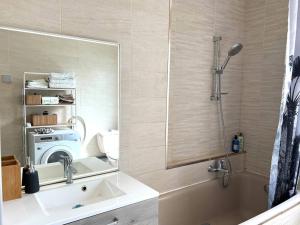 a bathroom with a mirror and a sink and a tub at Lumière Secrète Mulhouse Centre Parking Tram in Mulhouse