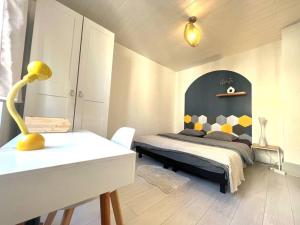 a bedroom with a bed and a table with a yellow lamp at Lumière Secrète Mulhouse Centre Parking Tram in Mulhouse
