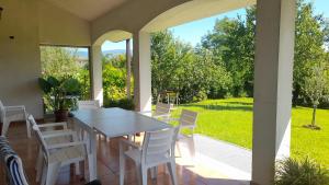 a porch with a white table and chairs on it at Etage entier independant d une villa , avec terrasse, jardin, 2 a 6 personnes in Arba +38 photos
