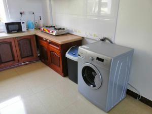a small kitchen with a washing machine in it at Deluxe Rooms in Shared Apartments in Dar es Salaam