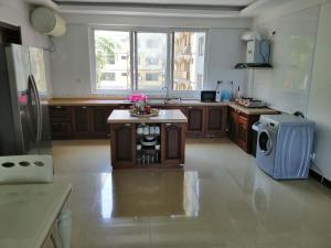a large kitchen with a stove and a microwave at Deluxe Rooms in Shared Apartments in Dar es Salaam