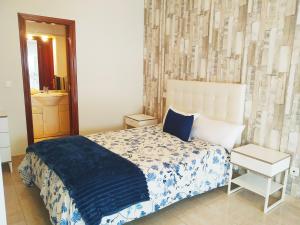 a bedroom with a bed with a blue and white blanket at LUNA AZUL, Centro Oviedo y con parking in Oviedo