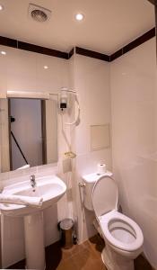 巴黎的住宿－Hotel Aix Europe，白色的浴室设有卫生间和水槽。