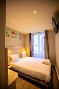 een slaapkamer met een groot bed en een raam bij Hotel Aix Europe in Parijs