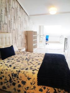 a bedroom with a bed with a yellow and blue bedspread at LUNA AZUL, Centro Oviedo y con parking in Oviedo