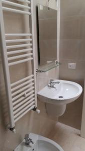 ポルト・チェザーレオにあるLa Vela Apartaments - Porto Cesareoのバスルーム(洗面台、トイレ、鏡付)